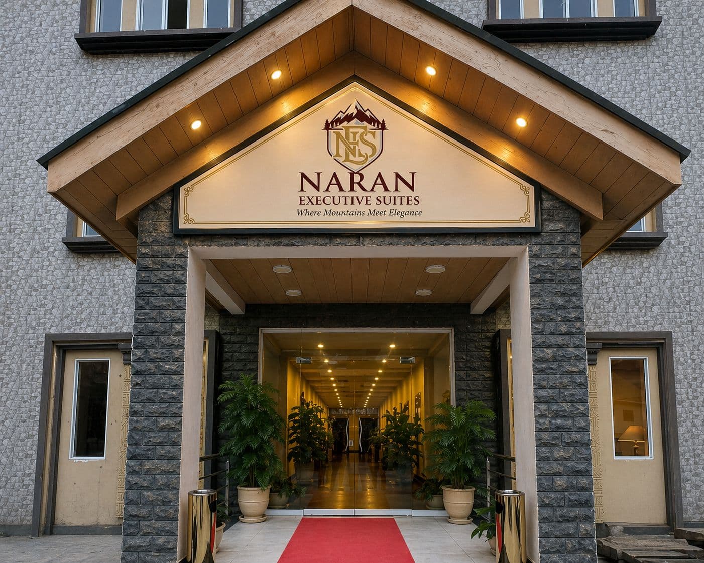 Naran Executive Suites — illuminated stone entrance with red carpet welcome