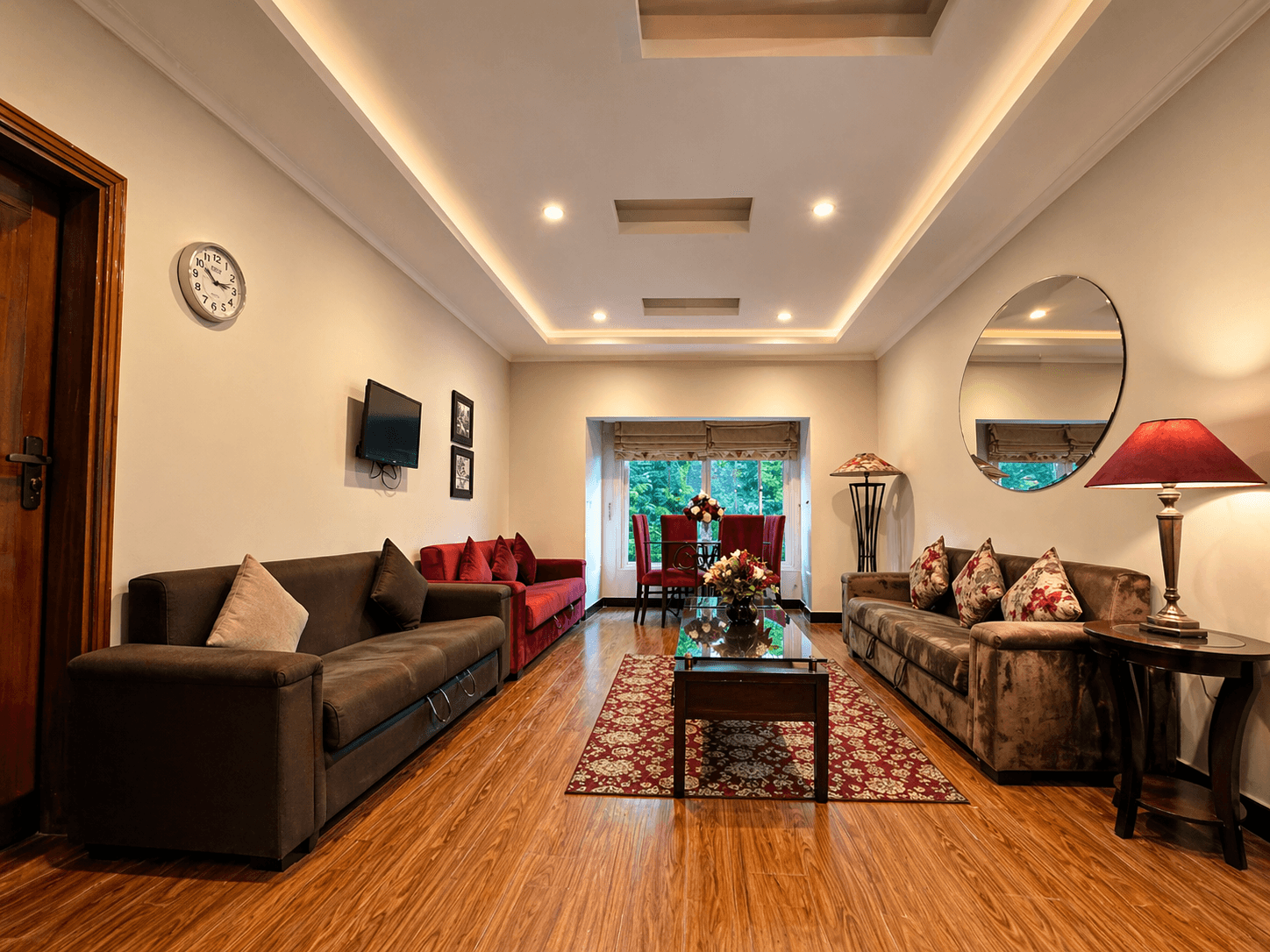 The lounge at Naran Executive Suites with brown velvet sofas and red accent chairs